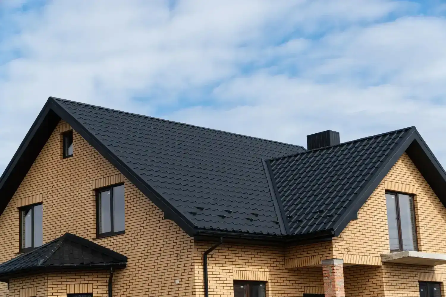 Home with a dark shingle roof at dusk